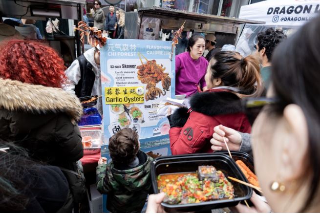 Chinese vendor taking orders of grilled seafood and skewers