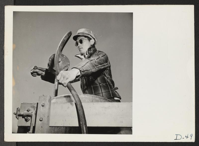 Man pumping gas from a barrel.