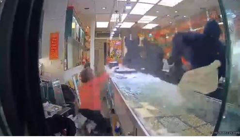 eight-masked burglars smash up a jewelry store case and make off with 90% of the store's inventory