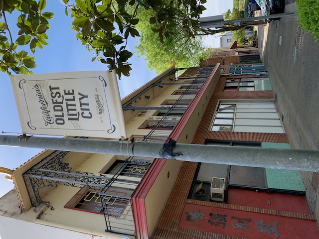 A sign in front a buildings on a downtown street.