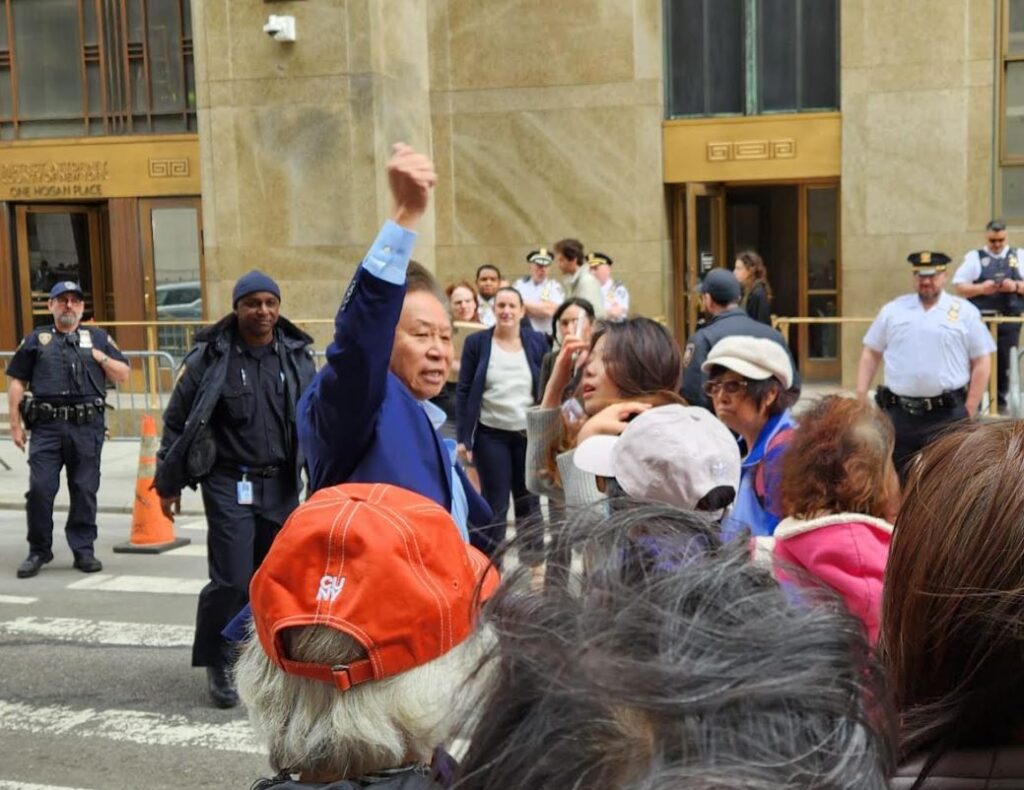 Activist Don Lee raises his fist in solidarity with the demonstrators 