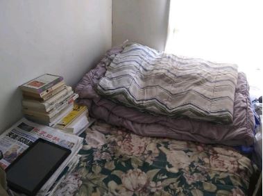 Yuan Yang lives with 9 roommates in a "family hotel" located in Monterey Park. His bed is separated from the neighboring bed by a wooden board.