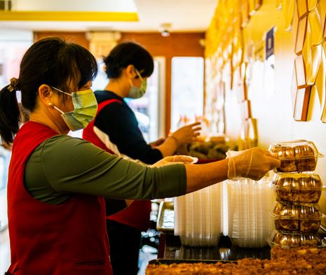 Two shopkeepers organize their merchandise