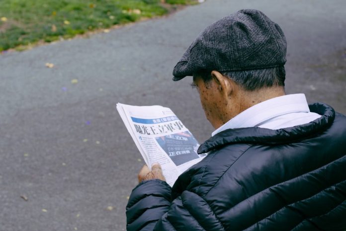 Asian senior reading a newspaper