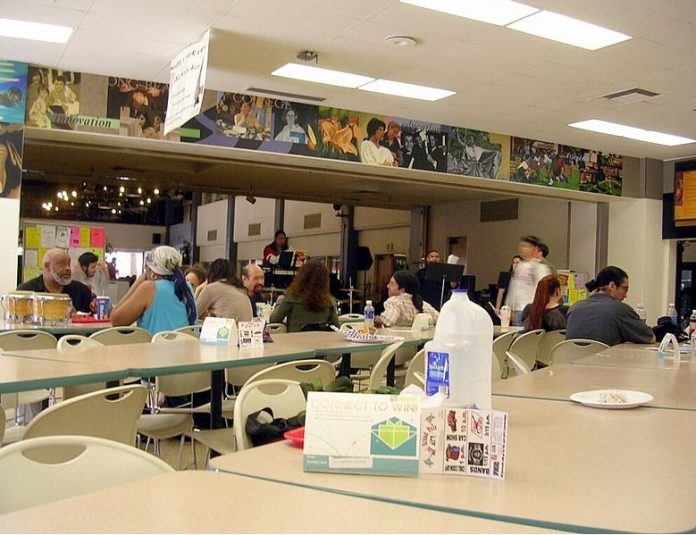 A light crowd sitting at the Long Beach City College (Liberal Arts Campus) cafeteria while a live jazz band performs on stage.