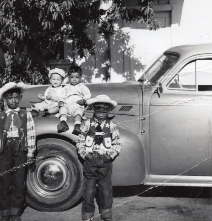 Photo of Filipino American children posing in front of a car