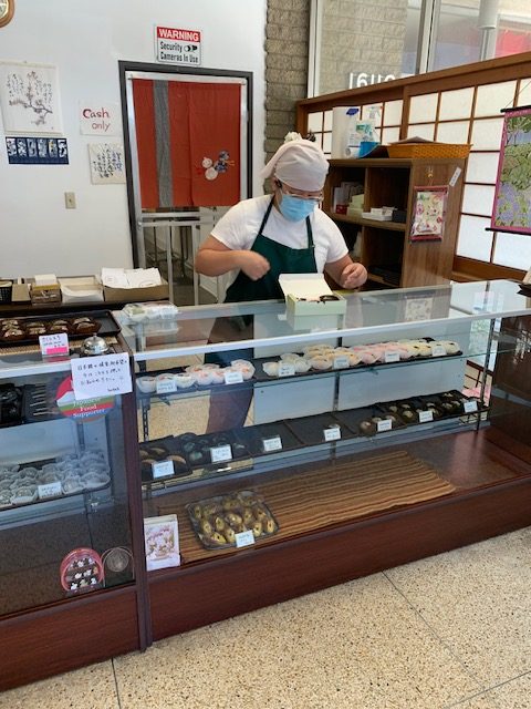 Clerk arranging Japanese sweet cakes.