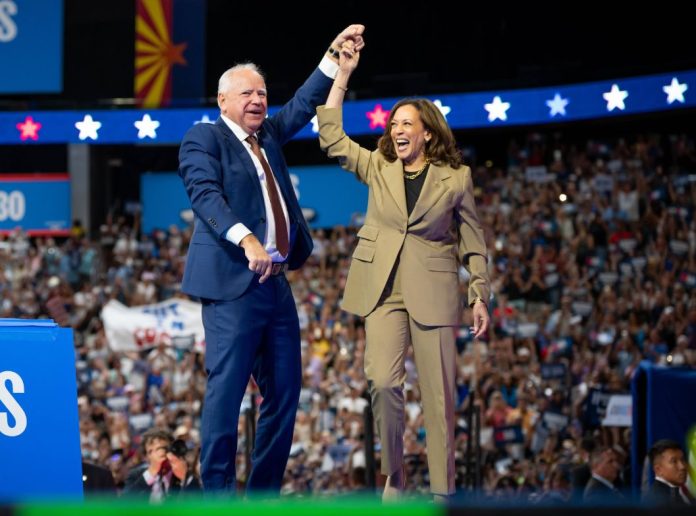 Kamala Harris and Tim Walz raise their hand in victory during a campaign rally on August 11, 2024