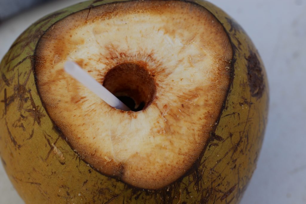 A bird's eye view of a coconut with a straw in it.