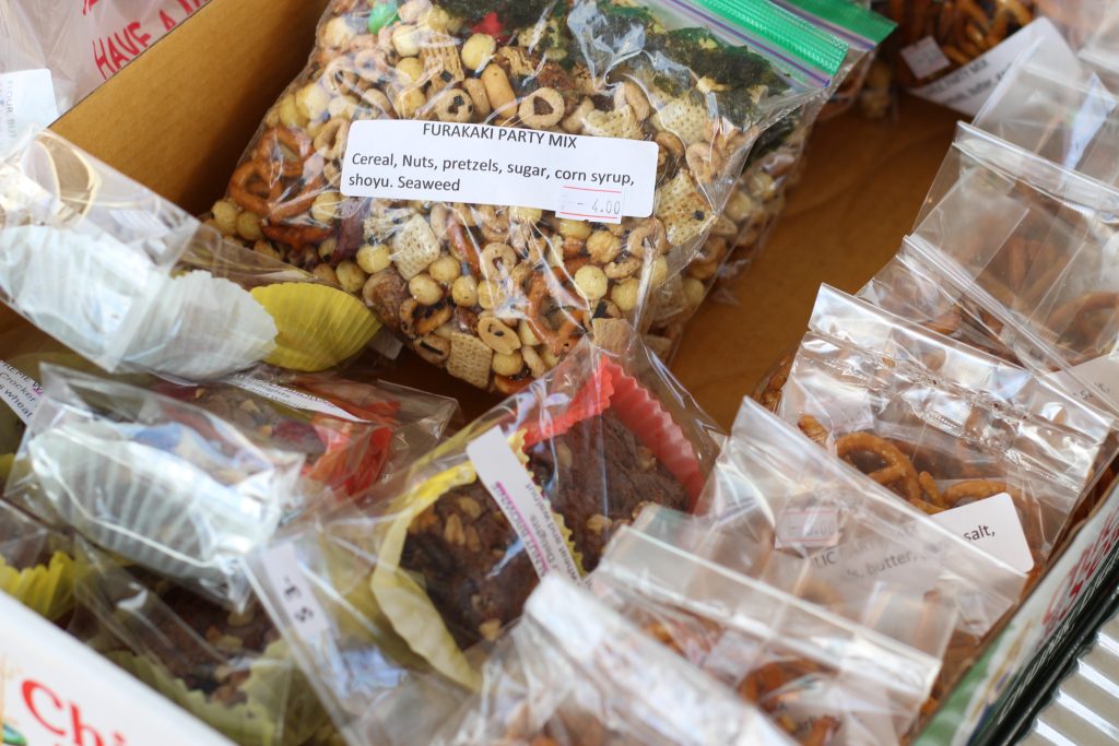 A box of snacks, including pretzels and furikake popcorn.