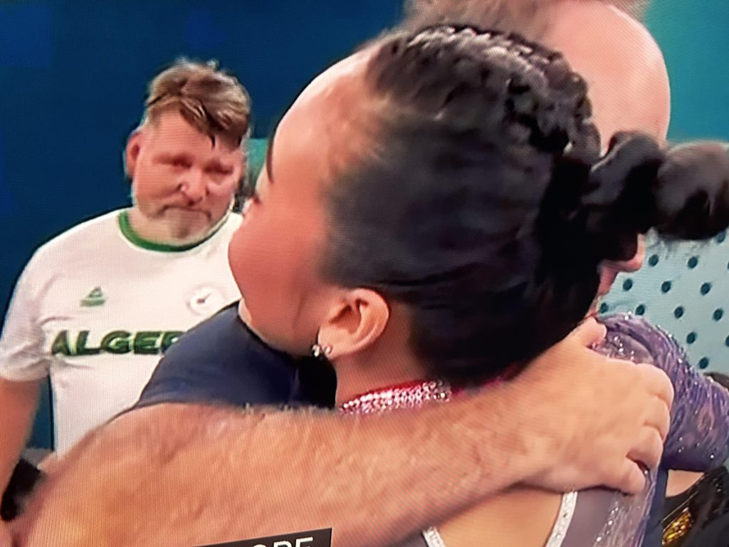 Suni Lee gets a big hug from her coach after completing her medal-clinching floor exercise at the Paris Olympics. 