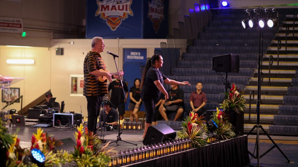 Maui mayor Richard Bissen plays ukelele and sings a song on stage.