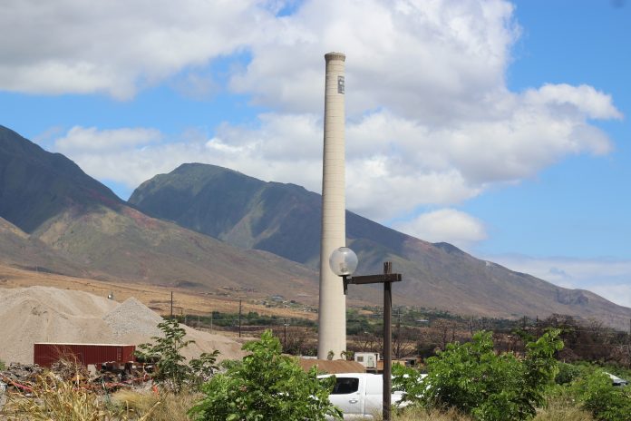 Lahaina's Pioneer Mill smokestack stands in the city's historical downtown, which burned down in last August's fires. A July structural evaluation found potential cracks and spalling concrete in the base. Photo by Yiming Fu.