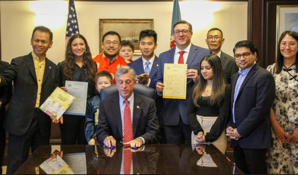 Supporters of a bill establishing a commission on AAPI Affairs in Delaware gather around Gov John Carney for the bill signing. 