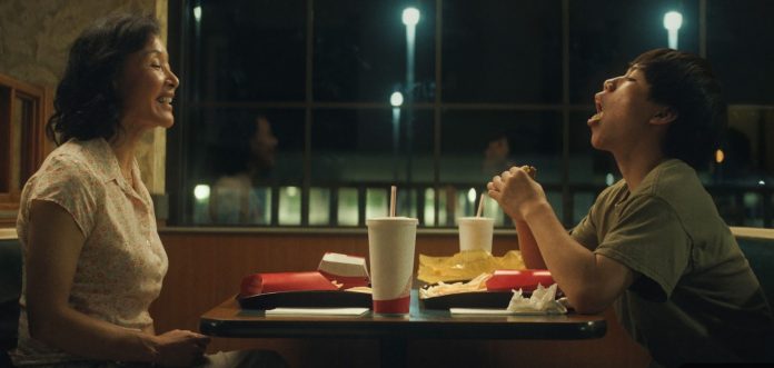 Izaac Wang as the son sits across from Joan Chen as the mother in Didi. They enjoy a milkshake at a local restaurant and Izaac leaves his mouth wide open in a light-hearted moment