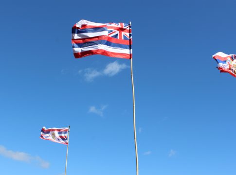 Three Hawaii state flags fly on flag poles