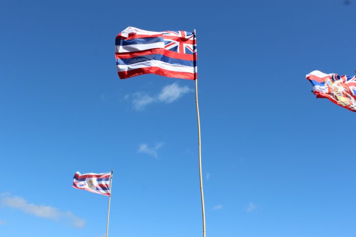 Three Hawaii state flags fly on flag poles