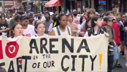 Marchers carry a large banner that reads 