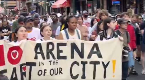 Marchers carry a large banner that reads 