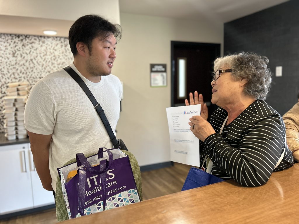 KCCEB's bilingual program manager Art Choi, left, listens to the experiences of Che Chun Hung, a displaced resident proficient in both Chinese and Korean, but not English. 