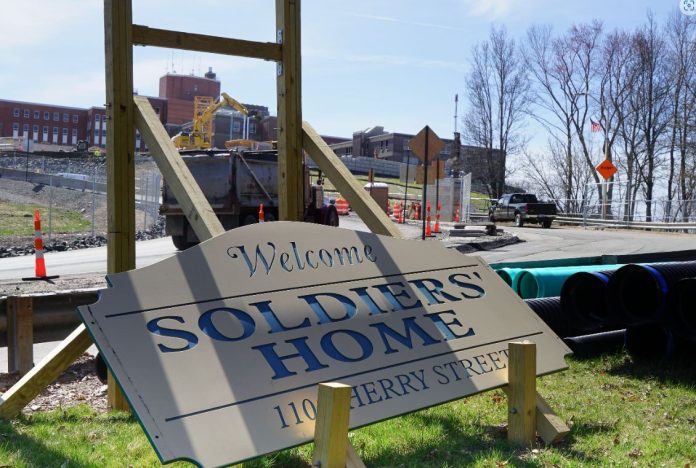 The state - run Soldiers’ Home in Holyoke, Mass achusetts , was the scene of o ne of the country’s deadliest covid outbreaks at a long - term nursing facility. Scrutiny of the outbreak prompted the state to change the home’s name, replace its leadership, and agree to a $5 6 million settlement for veterans and their families . But front - line caregivers have received little relief as they continue to grapple with the trauma . (Amy Maxmen/KFF Health News)