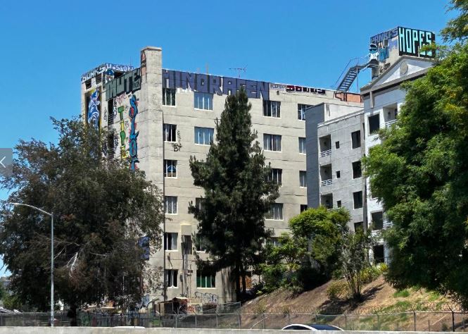 Sakura Intermediate Care Facility seen from a distance shows graffiti across the top of the building.