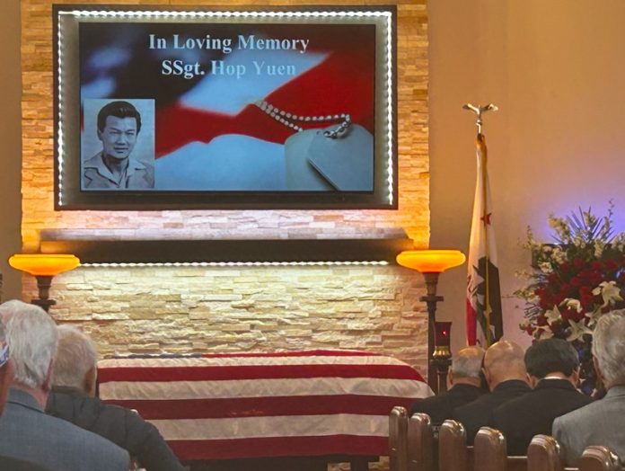 The funeral of Yuen Hop. His photo on an electronic display is right behind his casket draped in an American flag