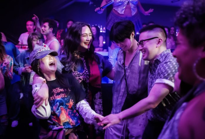 The Wedding Banquet stars Kelly Marie Tran, Lily Gladstone, Han Gi-Chan and Bowen Yang seen here laughing at a party
