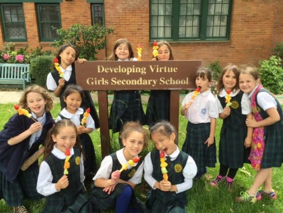 Instilling Goodness Elementary School students posing in front of Developing Virtue High School building, photo courtesy of CTTB