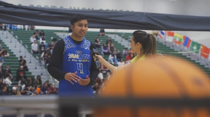 Pranav Iyer, founder of AMAZN HQ is being interviewed wearing a basketball jersey from AMAZN HQ's high school basketball showcase.