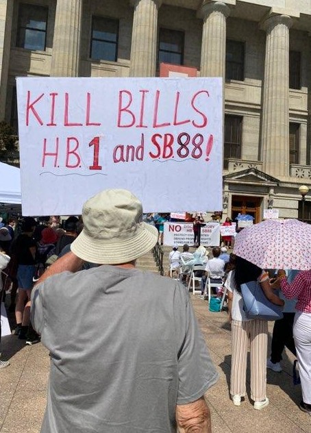 Hundreds braved scorching hot temperatures to rally against laws banning non-citizens from China and other countries from homeownership. One protest held a sign that read "Kill Bills" HB1 and SB88.
